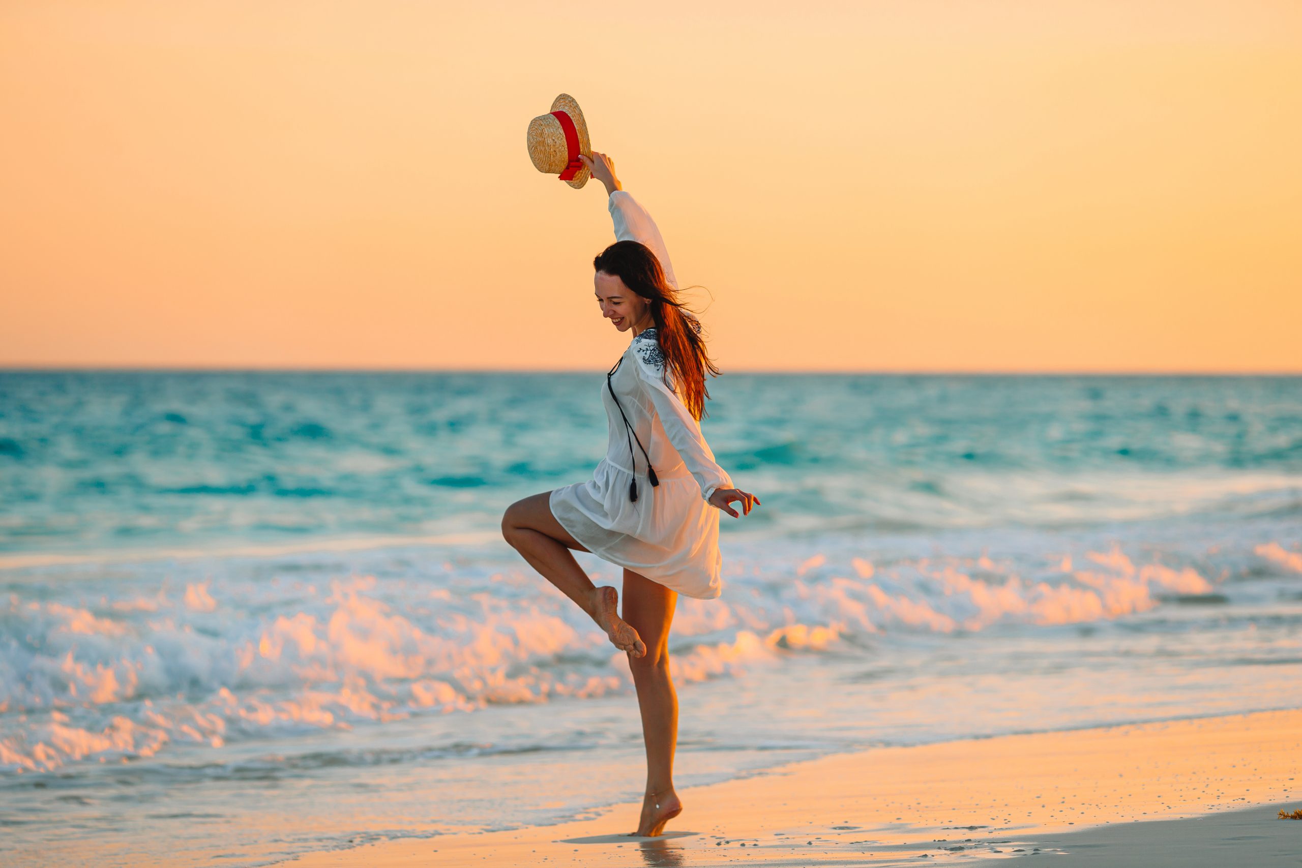 Young beautiful woman on tropical beach in sunset.
